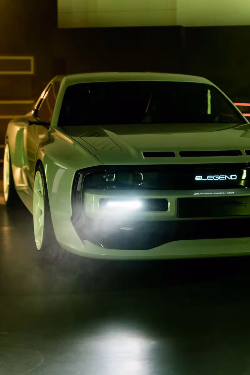 Grüner E-Legend Concept Car mit leuchtendem Schriftzug im dunklen Studio