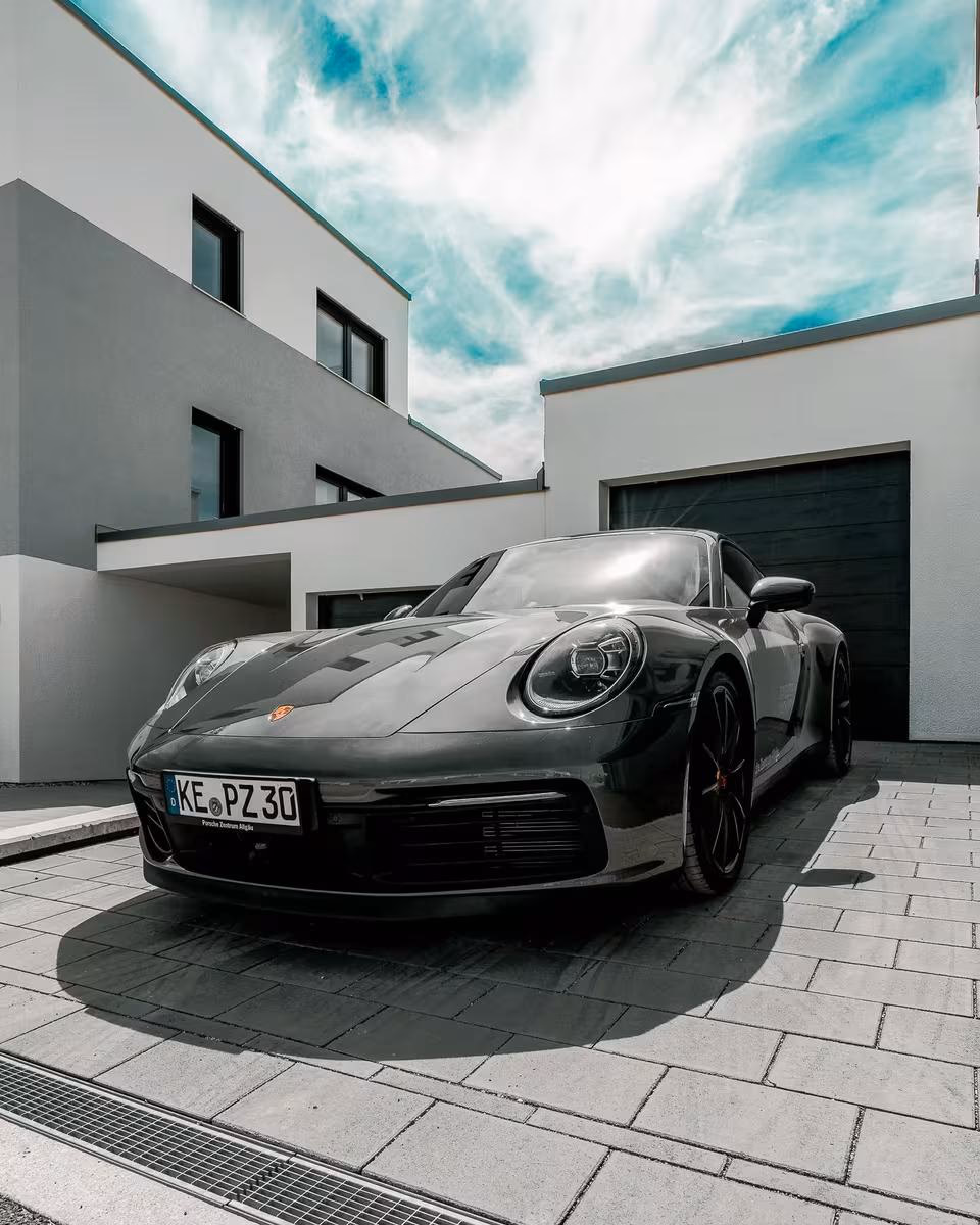 Schwarzer Porsche 911 Carrera 4S vor modernem Gebäude