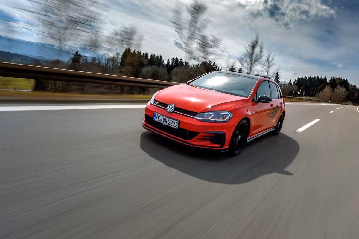 Volkswagen: Roter VW Golf GTI fährt mit hoher Geschwindigkeit auf einer Autobahn.