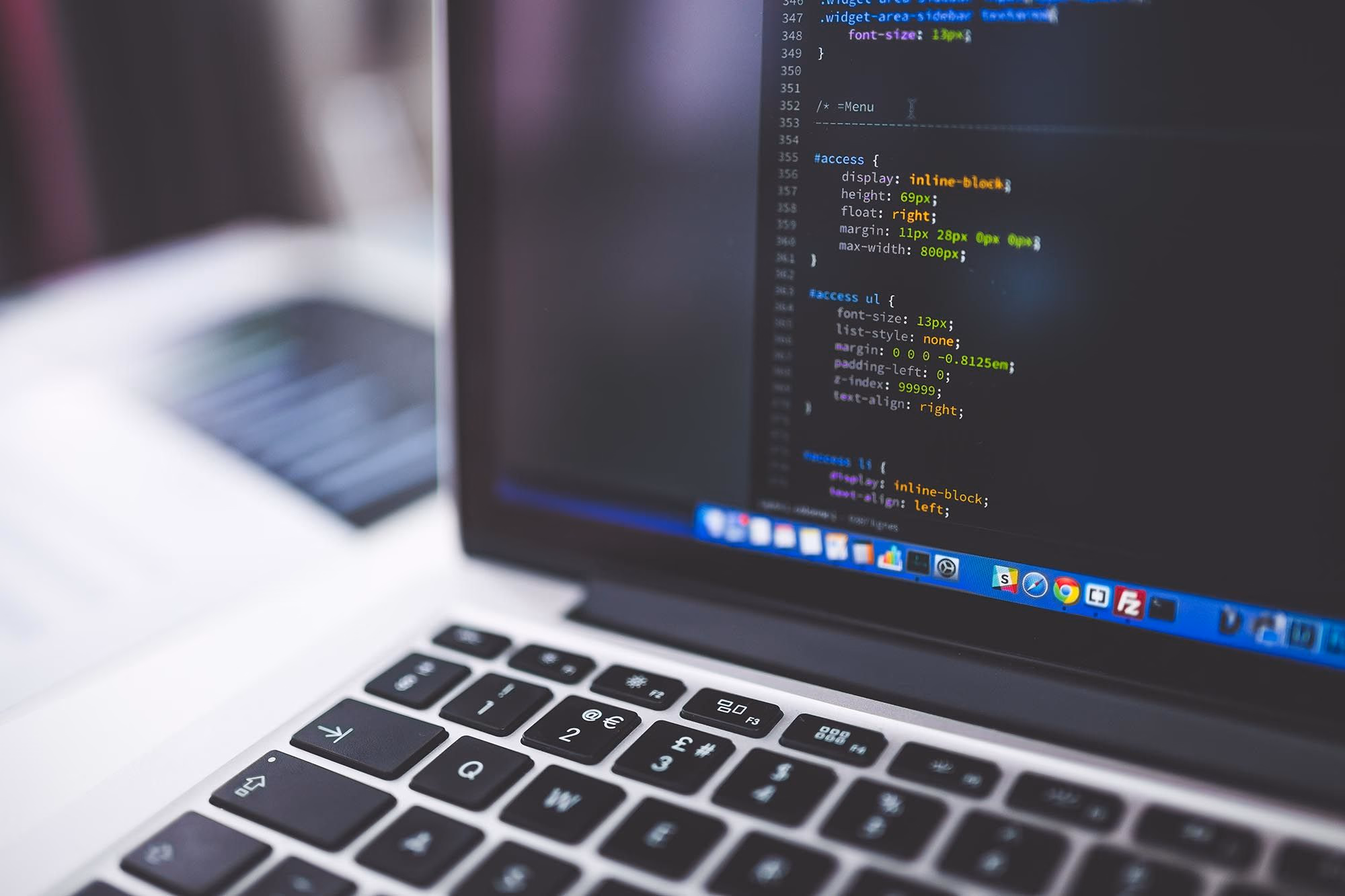 Laptop mit CSS-Code im Editor, Tastatur im Vordergrund