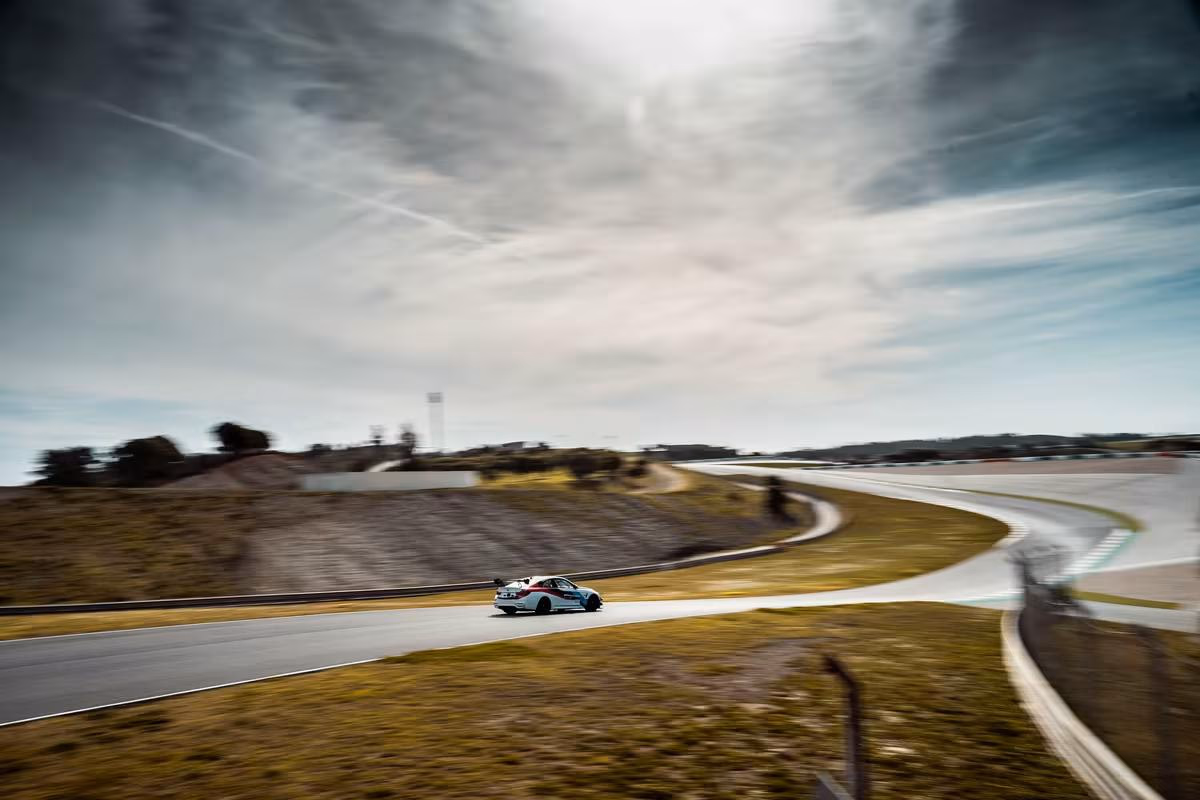 BMW Motorsport: BMW-Rennwagen fährt mit hoher Geschwindigkeit über eine Kurve der Rennstrecke.