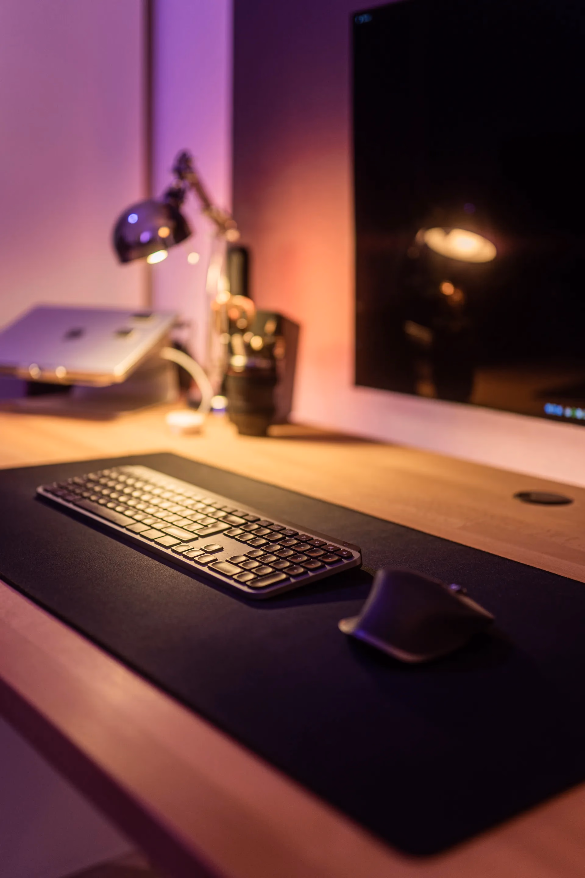 Schreibtisch mit Tastatur und Lampe im violetten Studiolicht